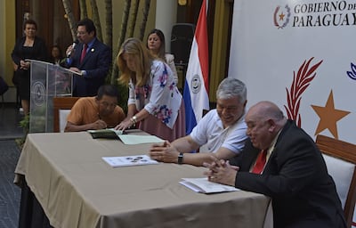 Líder indígena firma el título de propiedad de su comunidad, durante el acto en el Ministerio del Interior.