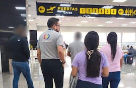 Cinco extranjeros en el aeropuerto Silvio Pettirossi mientras esperan su vuelo de regreso a sus tierras de origen.