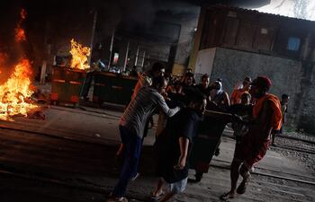 Personas bloquean un calle este viernes, durante una intervención de la policía militar en la favela de Moinho en Sao Paulo (Brasil). Los habitantes de la favela de Moinho, levantaron barricadas cerrando la entrada a la comunidad y la vía férrea, tras una operación de la policía militar.