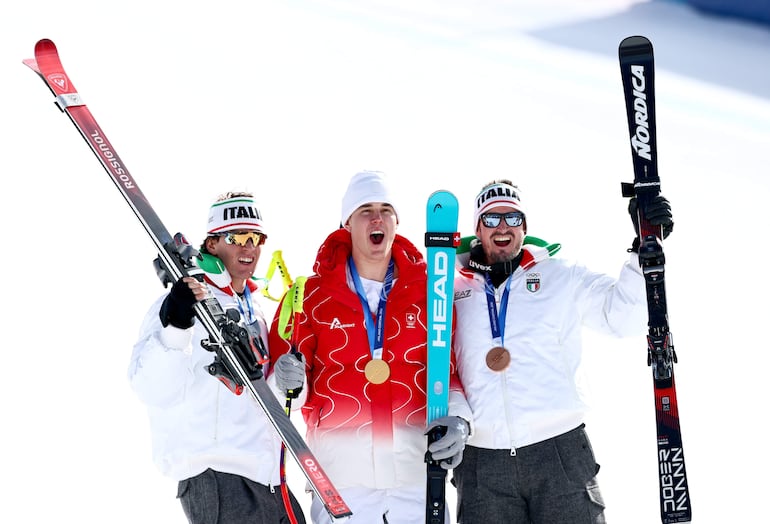 (I-D) El segundo clasificado Giovanni Franzoni de Italia, el ganador Franjo von Allmen de Suiza y el tercer clasificado Dominik Paris de Italia celebran durante la ceremonia de entrega de medallas después del descenso masculino de esquí alpino.