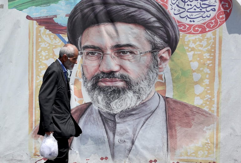 Un hombre iraní pasa junto a un cartel del líder supremo iraní, el ayatolá Mojtaba Khamenei, en una calle de Teherán, Irán.