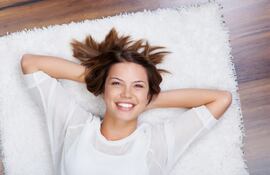 Mujer relajada sobre una alfombra.