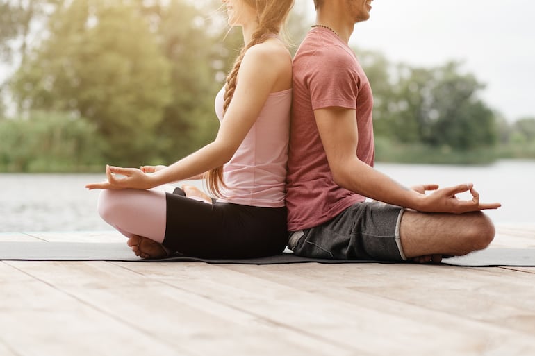 Pareja practicando meditación y respiración consciente.