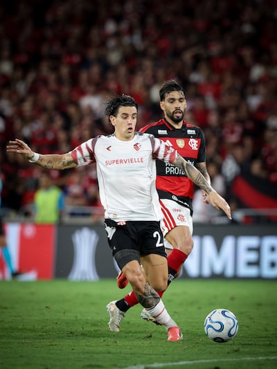 El mediocampista de Estudiantes de La Plata, Alexis Castro transporta el esférico ante la persecución del volante ofensivo de Flamengo Lucas Paquetá.