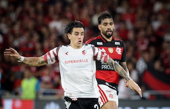 El mediocampista de Estudiantes de La Plata, Alexis Castro transporta el esférico ante la persecución del volante ofensivo de Flamengo Lucas Paquetá.