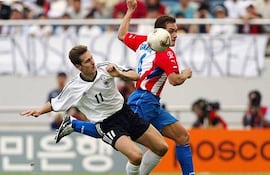 El zaguero de Paraguay, Carlos Gamarra intenta abortar el avance del delantero de Alemania, Miroslav Klose, en el duelo por los octavos de final del Mundial Corea-Japón 2002.