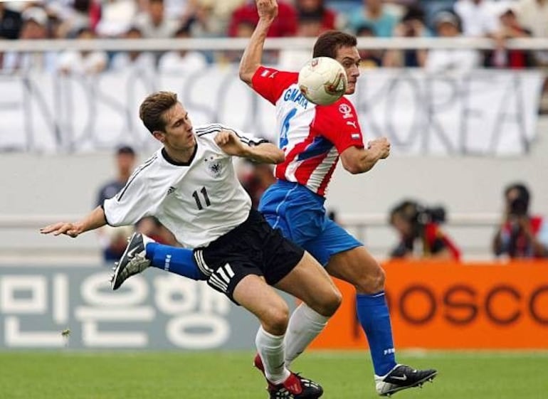 El zaguero de Paraguay, Carlos Gamarra intenta abortar el avance del delantero de Alemania, Miroslav Klose, en el duelo por los octavos de final del Mundial Corea-Japón 2002.