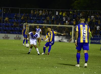 Diego Barreto trata de llevarse el balón ante la presencia de Jorge Mendoza, de Luqueño
