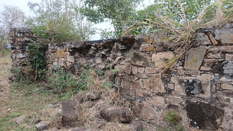 Muro de piedra en ruinas, rodeado de vegetaciòn