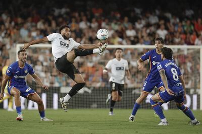 El centrocampista neerlandés del Valencia CF Arnaut Danjuma (2i) controla el balón durante el partido de la tercera jornada de LaLiga que Valencia CF y Getafe CF disputan este viernes en el estadio de Mestalla. EFE/Manuel Bruque
