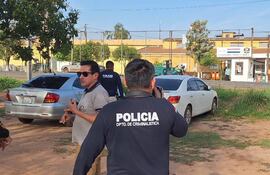 El fiscal Juan Daniel Benítez Miranda y agentes de la Policía cerca del auto Toyota Allion blanco del preso Marcelino Bogado Suárez, estacionado frente a la cárcel de San Pedro de Ycuamandyyú.