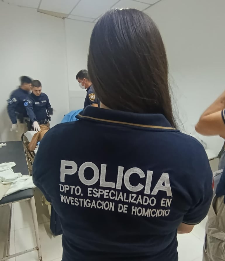 Agentes de Criminalística y de Homicidios verifican las heridas que sufrió la víctima.