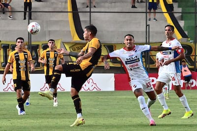 El defensor aurinegro Sebastián Zaracho saca ventaja hacia la pelota a Gaona Lugo. Más atrás, Roque, el autor del gol de la Academia.