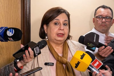 Esperanza Martínez, con blusa clara y abrigo a rayas, responde a preguntas de periodistas en sala de prensa.