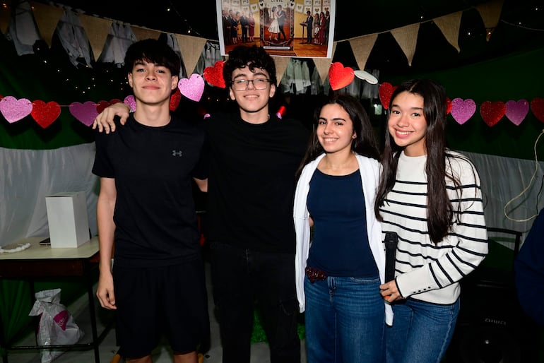 Cuatro adolescentes sonrientes, dos chicos a la izquierda y dos chicas a la derecha, decorados con corazones y guirnaldas.