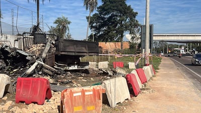 Camión volcado en la carretera rodeado de bloques de cemento en un área de construcción, sin personas visibles.