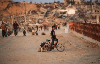Un niño palestino está sentado en su bicicleta en un puente en Nuseirat, Franja de Gaza, el 11 de noviembre de 2025.