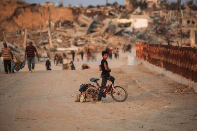 Un niño palestino está sentado en su bicicleta en un puente en Nuseirat, Franja de Gaza, el 11 de noviembre de 2025.