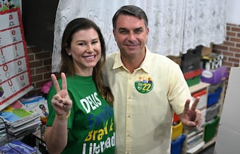 Flavio Bolsonaro, senador de derecha y candidato presidencial por el Partido Liberal (PL) de Brasil, y su esposa Fernanda Bolsonaro hacen el gesto de la "V" de la victoria en un centro de votación durante las elecciones presidenciales en Río de Janeiro, Brasil, el 4 de octubre de 2026. Los brasileños acuden a las urnas profundamente polarizados en una primera vuelta presidencial de resultado incierto y bajo la sombra del presidente estadounidense Donald Trump, quien ha respaldado a candidatos conservadores en recientes elecciones en América Latina.