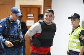 Policías quitan las esposas a su camarada procesado al llegar a la sala de juicio oral.