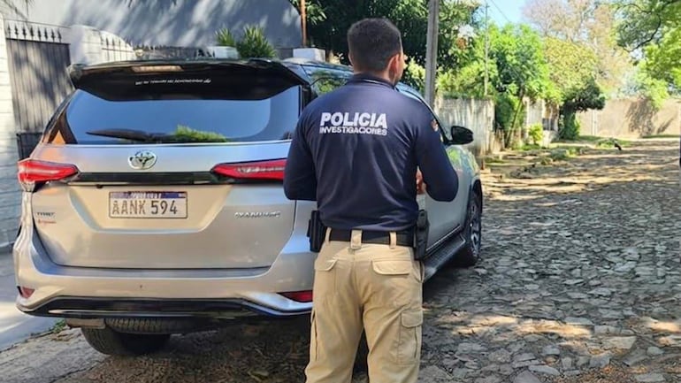 Un policía de Investigaciones junto a la camioneta Toyota Fortuner del brasileño.