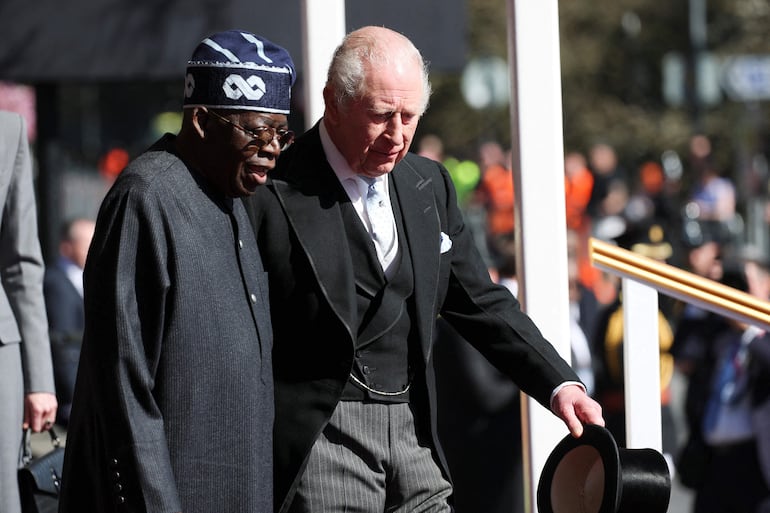 El rey Carlos III de Gran Bretaña saluda al presidente de Nigeria, Bola Tinubu, durante una ceremonia de bienvenida formal en Datchet Road, antes de una procesión en carruaje hacia el Castillo de Windsor. (Isabel Infantes / POOL / AFP)