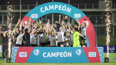 La celebración con el trofeo arriba de las gumarelas campeonas del Primer Torneo Anual de Fútbol Femenino de la APF. (@APFfutbolFEM)