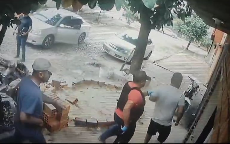 Los que serían el suboficial mayor Fidel Bernal Centurión (con chaleco) y el suboficial inspector Carlos Marcos Costa Ortiz (remera azul) introduce a las víctimas a la casa.