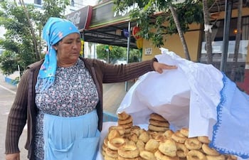 Máxima Noguera muestra la chipa de su producción que tiene en venta frente a la Basílica.