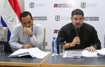 El director de administración y Finanznas, Edwin López Cattebeke (izq.) visiblemente preocupado durante una conferencia el 3 de julio pasado, mientras el intendente Óscar "Nenecho" Rodríguez intentaba negar el desvío de bonos.