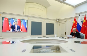 Elpresidente de Rusia, Vladimir Putin (d) saluda a su par chino, Xi Jinping, durante una videoconferencia, hoy.
