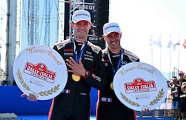 El veterano piloto francés, Sébastien Ogier, de 41 años, festeja el logro con su trofeo en la mano derecha –junto a Vincent Landais– haciendo el número 5 con su izquierda después de completar su corona número 5 en el Rally de Sardegna, en Italia.