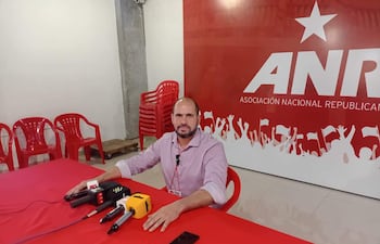Santiago Brizuela, con camisa clara y expresión tranquila, se sienta frente a una mesa con micrófonos y logotipo de la ANR de fondo.