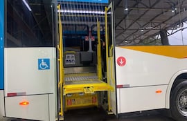Autobús urbano azul y blanco con rampa desplegada, simbolizando accesibilidad en un terminal.
