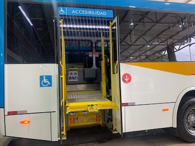 Autobús urbano azul y blanco con rampa desplegada, simbolizando accesibilidad en un terminal.