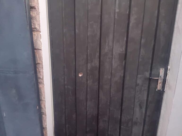 Puerta de una vivienda con un impacto de bala, que se dio tras el tiroteo con persecución que derivó de un intento de asalto en Fernando de la Mora, zona sur.