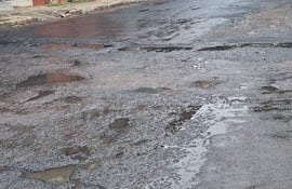 Calle Patria y San Francisco en Asunción, con pavimento agrietado y charcos de agua, sin presencia de personas.