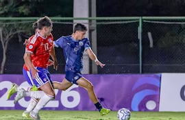 Giovanni López (d), de Paraguay, alista un remate al arco ante la marca de dos rivales chilenos.