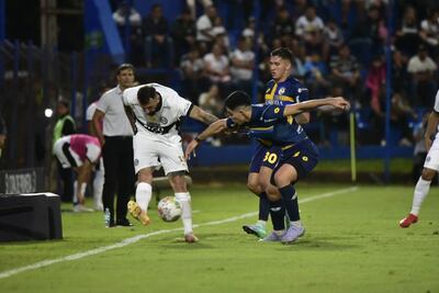 E atacante de Olimpia, Lucas Pratto intenta extender el pase ante la presencia del volante Juan Salcedo.