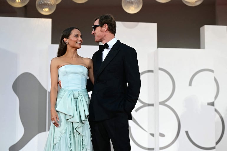 La actriz sueca Alicia Vikander y el actor germano-irlandés Michael Fassbender en la alfombra roja previa a la proyección de "The Echo Chamber", presentada a concurso en la 83.ª edición del Festival Internacional de Cine de Venecia, en el Lido de Venecia. (Stefano Rellandini / AFP)