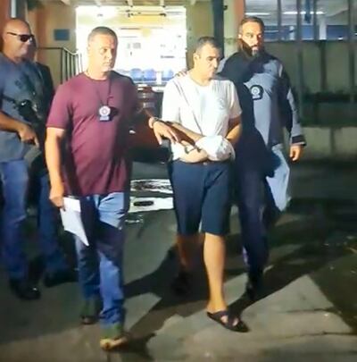 Esposado y bajo custodia de agentes policiales brasileños, Miguel Ángel Insfránm alias tío Rico, cuando fue detenido en Rio de Janeiro, Brasil, en febrero del año pasado.