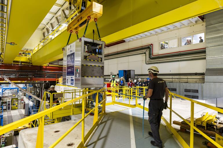 Técnicos trasladan una trampa de antimateria transportable al Antimatter Factory del CERN en Meyrin, cerca de Ginebra, el 24 de marzo de 2026, antes de una prueba en carretera en la que científicos transportaron antimateria en camión por primera vez. La trampa mide 2 metros de largo, 1,58 metros de alto y 0,87 metros de ancho, y pesa alrededor de una tonelada.