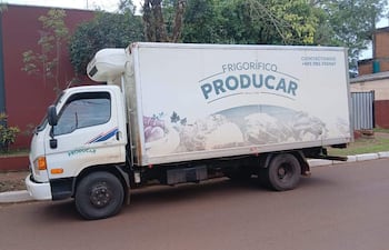 Camión de frigorífico PRODACAR aparcado en calle de tierra, con logo y productos alimenticios visibles en su costado.