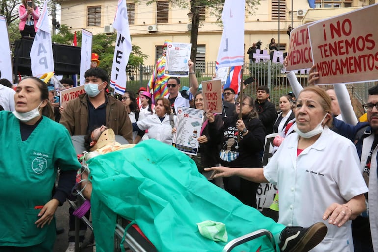 Un grupo de médicos participa en una protesta este lunes, en Asunción (Paraguay). Médicos del sector público marcharon y protagonizaron concentraciones en Paraguay, en el primer día de una huelga general que han convocado hasta el viernes para exigir un reajuste salarial, mejores condiciones laborales y la dotación de insumos y medicamentos en los hospitales. EFE/ Nina Osorio