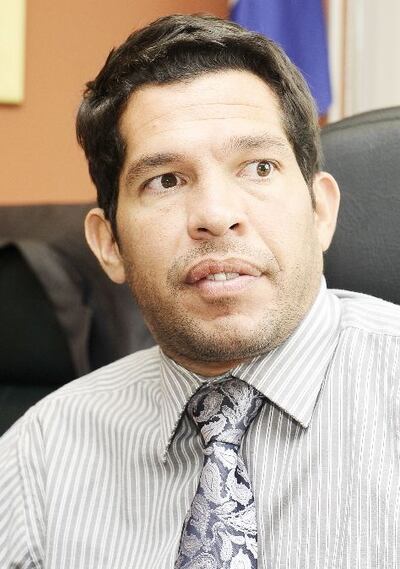 El Dr. José Agustín Delmás, con camisa a rayas y corbata estampada, reflexiona en un entorno neutro.