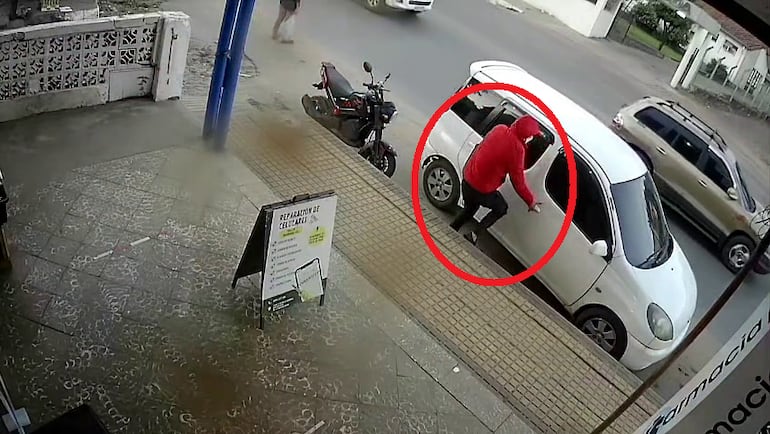 Captura de circuito cerrado del momento en que el sospechoso aborda el vehículo en el que escapa tras el asalto.