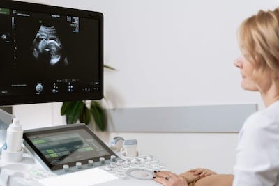 Obstetra observa una ecografía en consultorio.