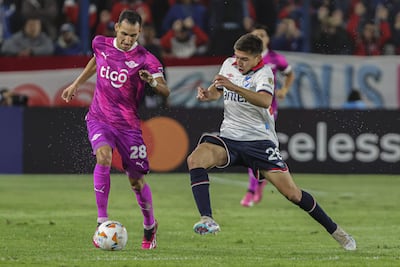 El paraguayo Marcelo Fernández (i), jugador de Libertad, pelea por el balón en un partido frente a Nacional por la fase de grupos de la Copa Libertadores 2024 en el estadio Gran Parque Central, en Montevideo, Uruguay.