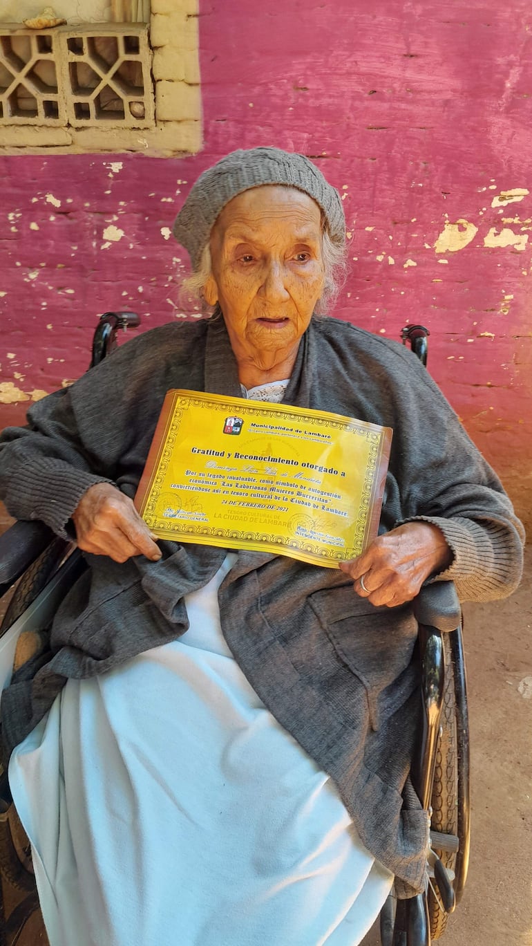 La burrerita María Dominga León viuda de Mendieta muestra el reconocimiento otorgado por la Municipalidad de Lambaré en el año 2021.