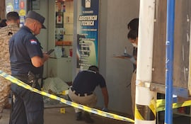 Agentes de la Policía Nacional trabajan en la escena del crimen, frente a la tienda TS Celulares que fue asaltada en la avenida San José del barrio Ciudad Nueva de Ciudad del Este.